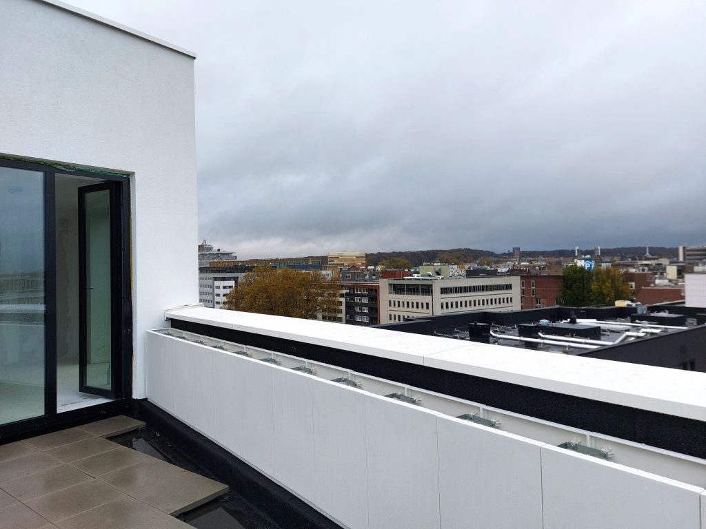 Dakterras in aanleg in Arnhems Blond Huis met plantenbakken en zicht op de stad